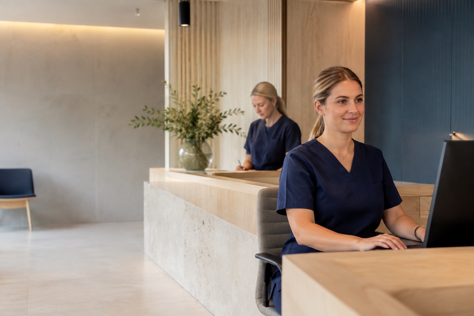 Illustrativ mottagningsmiljö med två kollegor i receptionen.